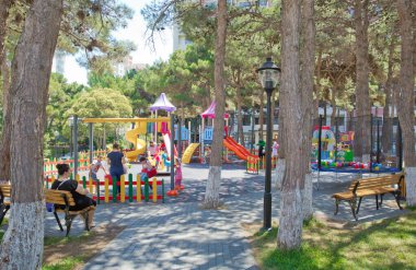 Çocuk okulu ya da şehir bahçesi için büyük plastik oyuncaklar seti. Çocuklar oyun parkında oyun ekipmanları açık havada. Parkta slaytlı çocuk parkı. Çam ağaçları