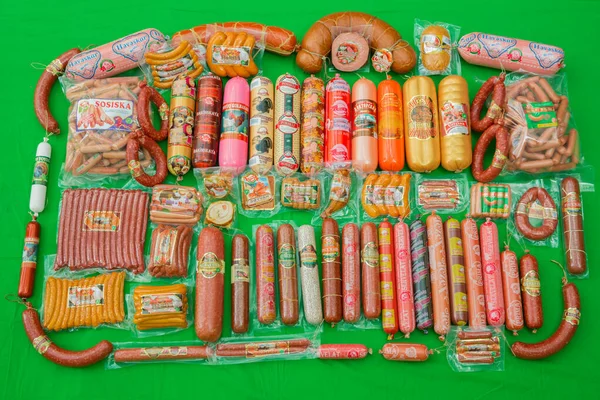 Azerbaycan baku: 27.04.2017. Birçok jambonlu sosis paketi yeşil arka planda izole edildi. Bir grup lezzetli haşlanmış sosis. Bir sürü sosis. Farklı lezzetli sosislerle hazırlanmış.