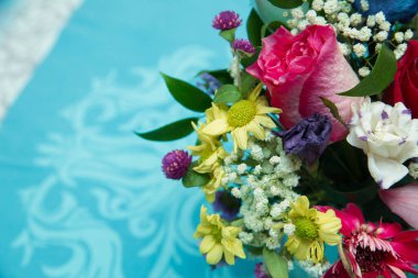 Tepesinde çok renkli sarı buket var. Masada bir buket çiçek. Gökkuşağı papatyası. Kasımpatı Gökkuşağı Çiçeği. Çiçek açan gökkuşağı kasımpatı buketleri