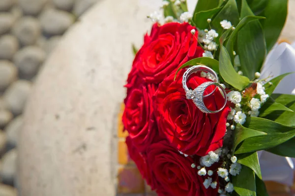 花嫁と新郎は赤いウェディングブーケにリング 結婚式のためのバラの花束 — ストック写真