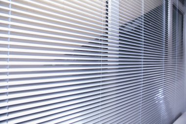 Pencereden Venedik panjurlarından gelen güneş ışığı. Ofis perdeleri. Modern ahşap külüstür. Ofis toplantı odası ışıklandırma aralığı kontrolü. Pencere kenarındaki Venedik panjurları