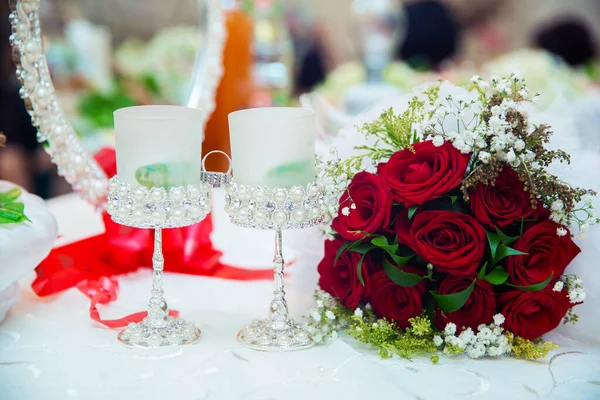 结婚的一束红花 玫瑰上有水滴 婚戒放在红玫瑰上 婚戒在杯子的中间 — 图库照片