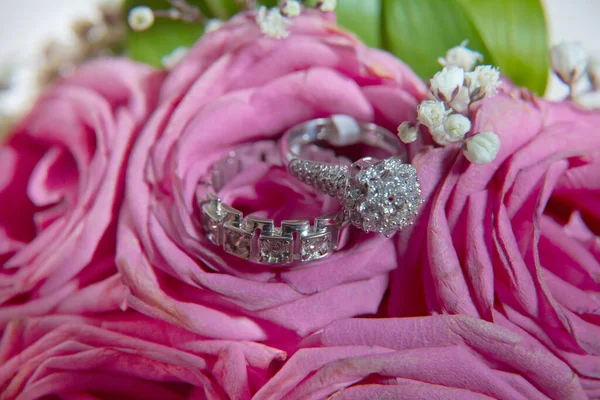 新娘和新郎在一束粉红色的花上挂着戒指 新娘的花束上有结婚戒指华丽的结婚花束粉红色的玫瑰 特写镜头 — 图库照片