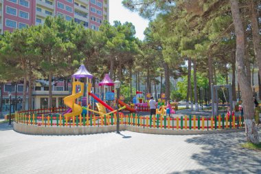 Çocuk okulu ya da şehir bahçesi için büyük plastik oyuncaklar seti. Çocuklar oyun parkında oyun ekipmanları açık havada. Parkta slaytlı çocuk parkı. Çam ağaçları