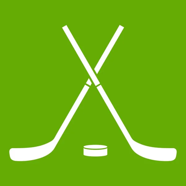 Crossed hockey sticks and puck icon green — Stock Vector
