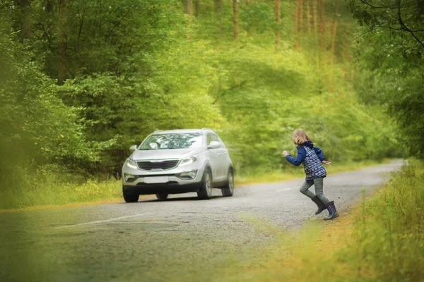 Situación peligrosa en la carretera, el niño corre a través de la carretera delante del coche —  Fotos de Stock