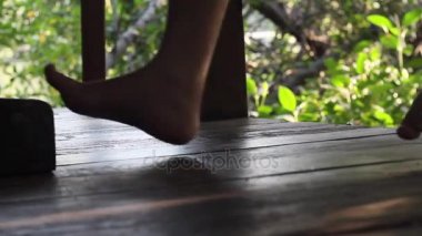 Salıncak ayak tarafından rahatlatıcı ve bahçedeki çardağın oturan adam, kapatmak.