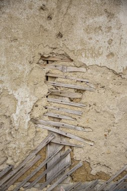 Çatlak kerpiç duvar dokusunu kapat, Bulgar Köyü 'ndeki çamurdan bir evin kil duvarı..