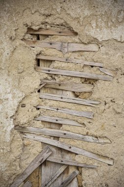 Çatlak kerpiç duvar dokusunu kapat, Bulgar Köyü 'ndeki çamurdan bir evin kil duvarı..