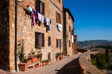 Renkli giysi ile eski taş evler. Pienza, İtalya.