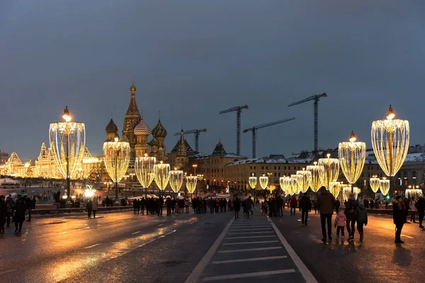 Mosca, Russia - 5 gennaio 2018: Cremlino, St. Cattedrale di Basilio e il ponte Moskvoretsky Grande nella notte invernale con illuminazione di anno nuovo in vacanze con persone che camminano — Foto Stock