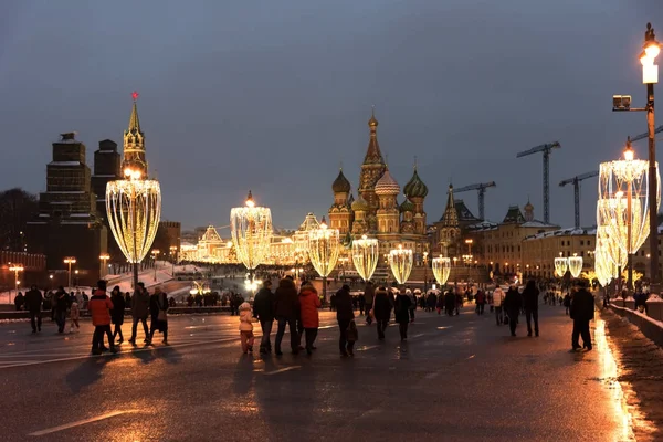 Mosca, Russia - 5 gennaio 2018: Cremlino, St. Cattedrale di Basilio e il ponte Moskvoretsky Grande nella notte invernale con illuminazione di anno nuovo in vacanze con persone che camminano — Foto Stock