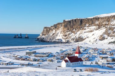 Vik I Myrdal kilisesinin İzlanda 'daki tepenin üstündeki görüntüsü. İzlanda 'da kışın Vik ve Myrdal kiliselerinin panoramik manzarası