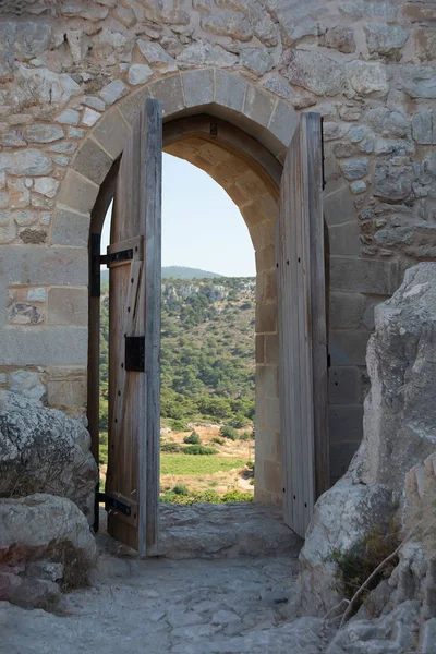 Antiguo arco de madera en la fortaleza con puertas abiertas. Arco en muro de piedra. Rodas — Foto de Stock