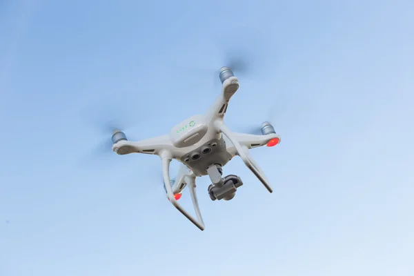 Flying quadcopter in blue sky — Stock Photo, Image