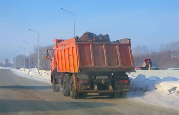 Lastbil transporterar jord på vinterväg — Stockfoto