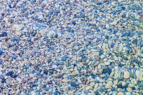 Різнокольорові гальки під водою на пляжі — стокове фото