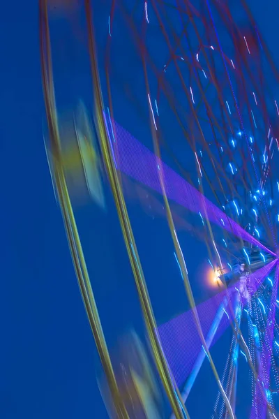 Carnival ride showing a spinning ferris wheel in action — Stock Photo, Image
