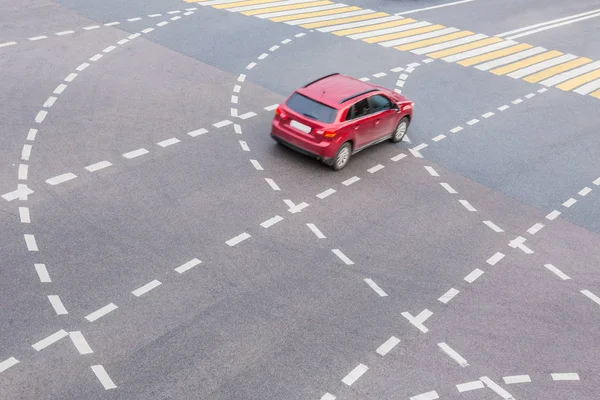 Červené auto na křižovatce s označením — Stock fotografie