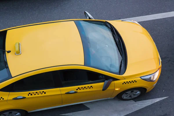 Sarı taksi şehrin üzerinde hareket eder. — Stok fotoğraf