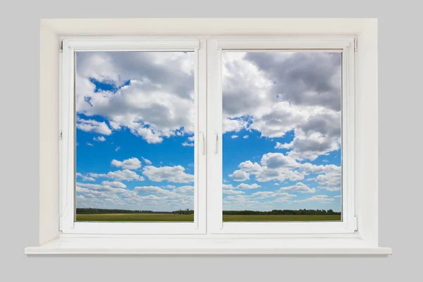 Paysage de fenêtre avec ciel nuageux et champ — Photo