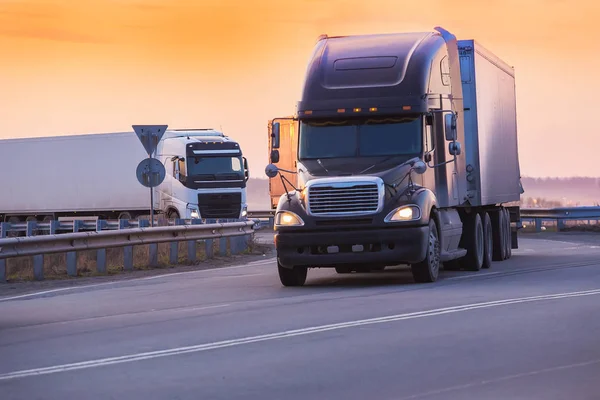 Trucks goes on highway on sunset — Stock Photo, Image