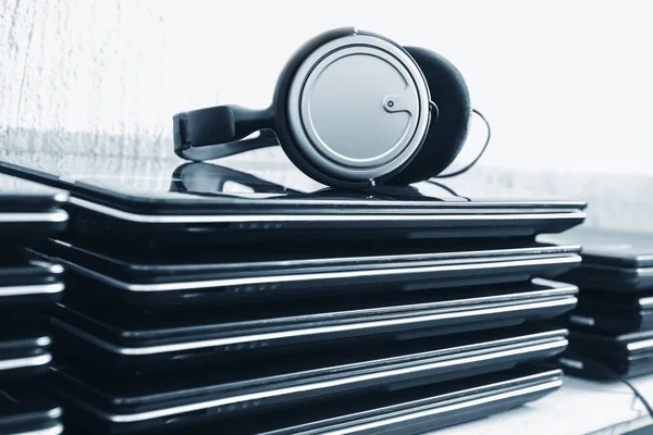 Słuchawki na stos laptopów — Zdjęcie stockowe