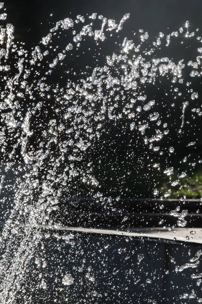 Фонтан капель воды на темном фоне
