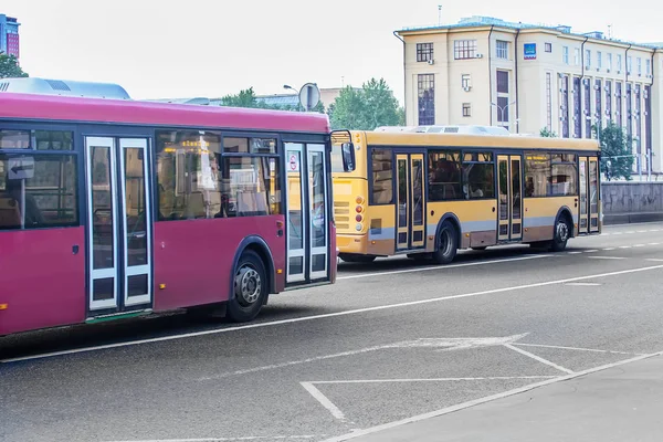 Dos autobuses van en la calle de la ciudad — Foto de Stock