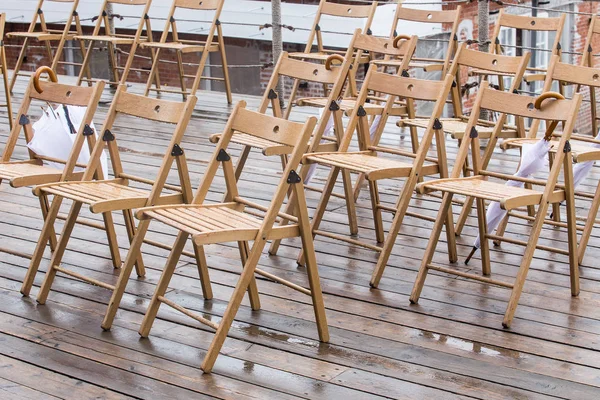 Wooden chairs and umbrellas in the rain — Stock Photo, Image