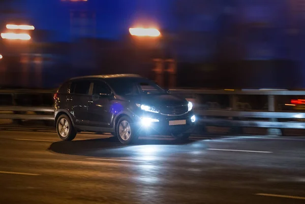 SUV rider på natten på motorvägen — Stockfoto