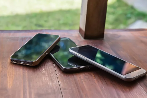 Smartphones en un porche de madera — Foto de Stock