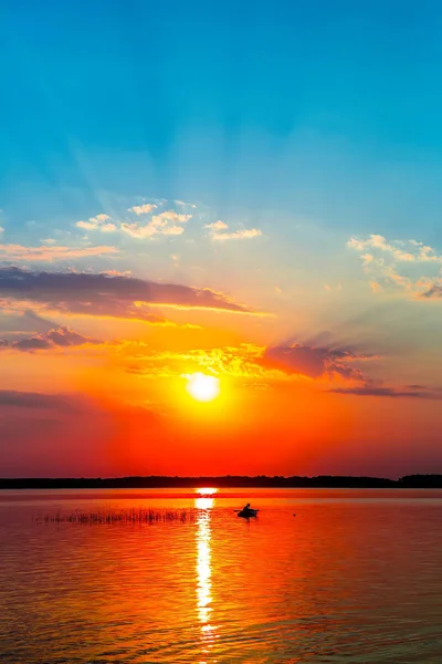 Fisherman by boat fishes on lake — Stock Photo, Image