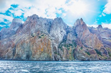Kayalar güneşli gökyüzü altında sahilde