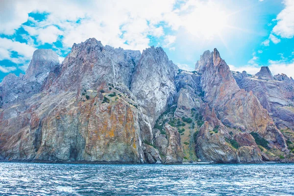 Kayalar güneşli gökyüzü altında sahilde