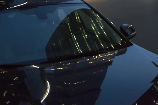 Reflectie van meerdere verdiepingen gebouwen op de motorkap van de auto bij n — Stockfoto