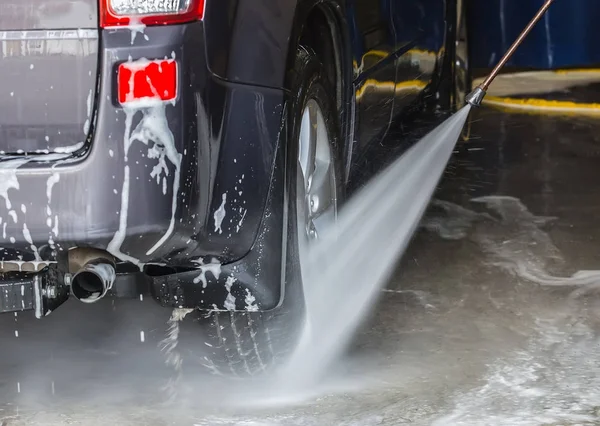 Car on a sink under a stream of water — Stock Photo, Image