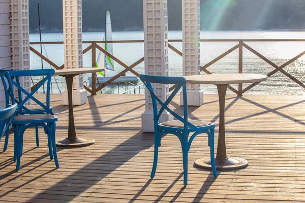 Cafe poza drewniany stół i krzesło nad morzem w jes — Zdjęcie stockowe