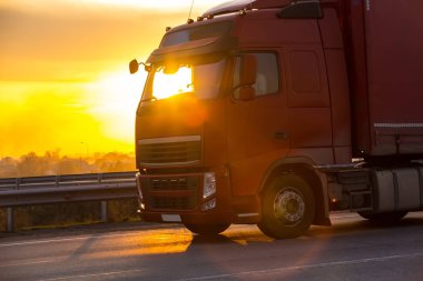 kamyon otoyolda günbatımı üzerinde gider.