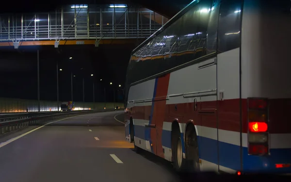 Autobus przenosi się w nocy autostrady — Zdjęcie stockowe
