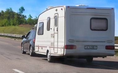 Bir kamp römork ile Suv yol boyunca hareket ediyor
