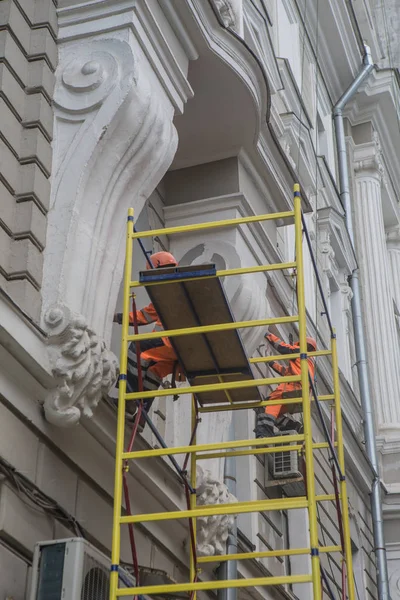 Arbeiter restaurieren Fassade eines Gebäudes — Stockfoto