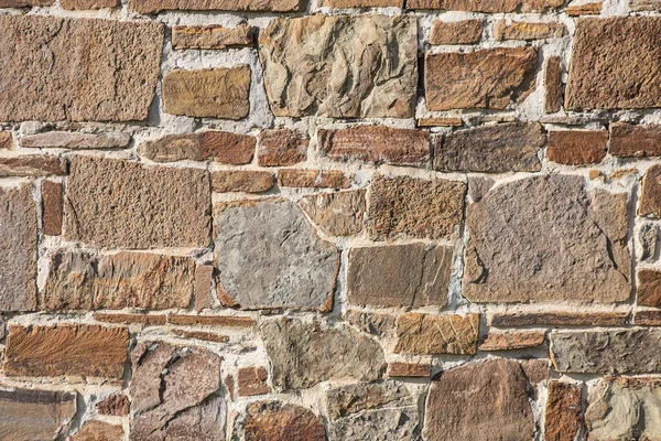 Stone wall of rough unprocessed stones — Stock Photo, Image
