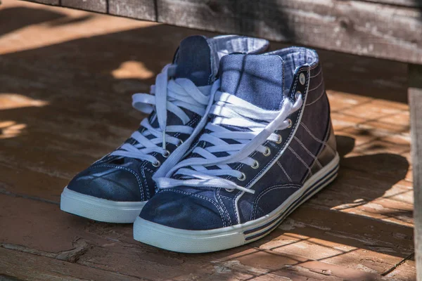 Scarpe da ginnastica in denim blu da uomo su un vecchio pavimento — Foto Stock