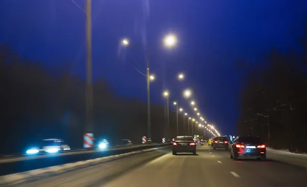 El tráfico de coches en invierno en la carretera por la noche . — Foto de Stock