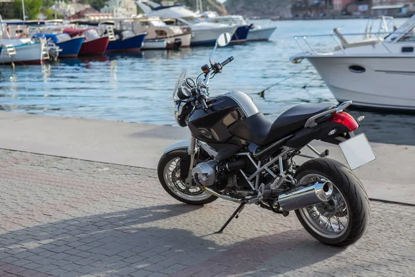 Motorcycle on the pier near moored yachts — Stockfoto