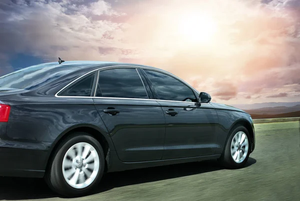 Black prestigious car rides on the highway against the sky — Stock Photo, Image