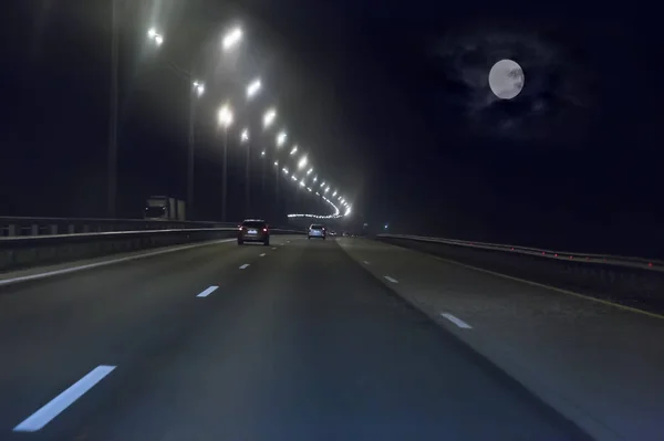 Coches con luces en movimiento en la carretera ancha de varios carriles por la noche —  Fotos de Stock