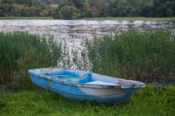 Velho barco de pesca na grama junto ao rio — Fotografia de Stock