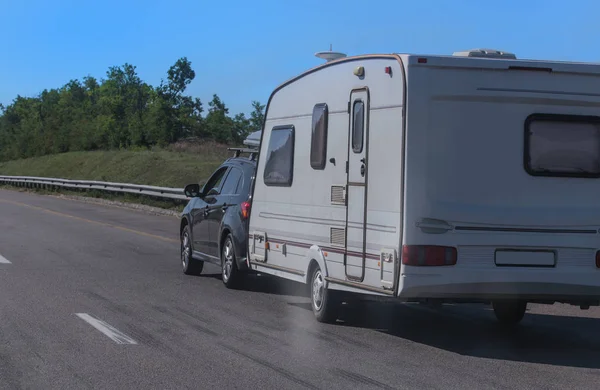 SUV with a camping trailer is moving along the road — Stock Photo, Image